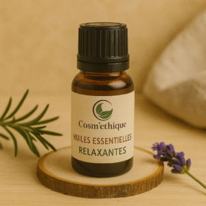 Flacon d’huile essentielle relaxante Cosm’éthique posé sur une planche en bois avec plantes aromatiques.